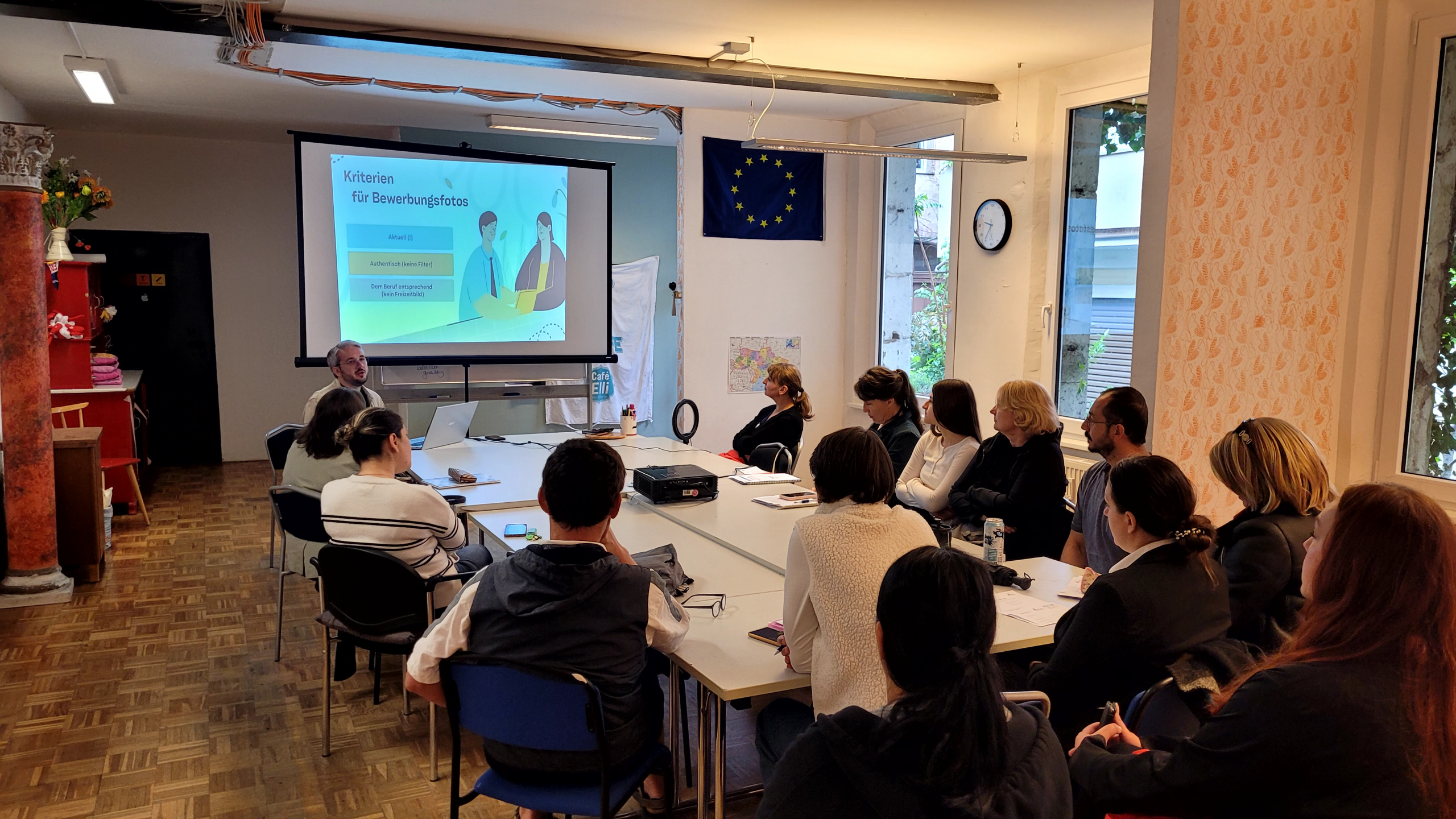 Job2Go-Workshop 2026 Eine Gruppe Menschen sitzt um einen Konferenztisch und hört einem Referenten zu.